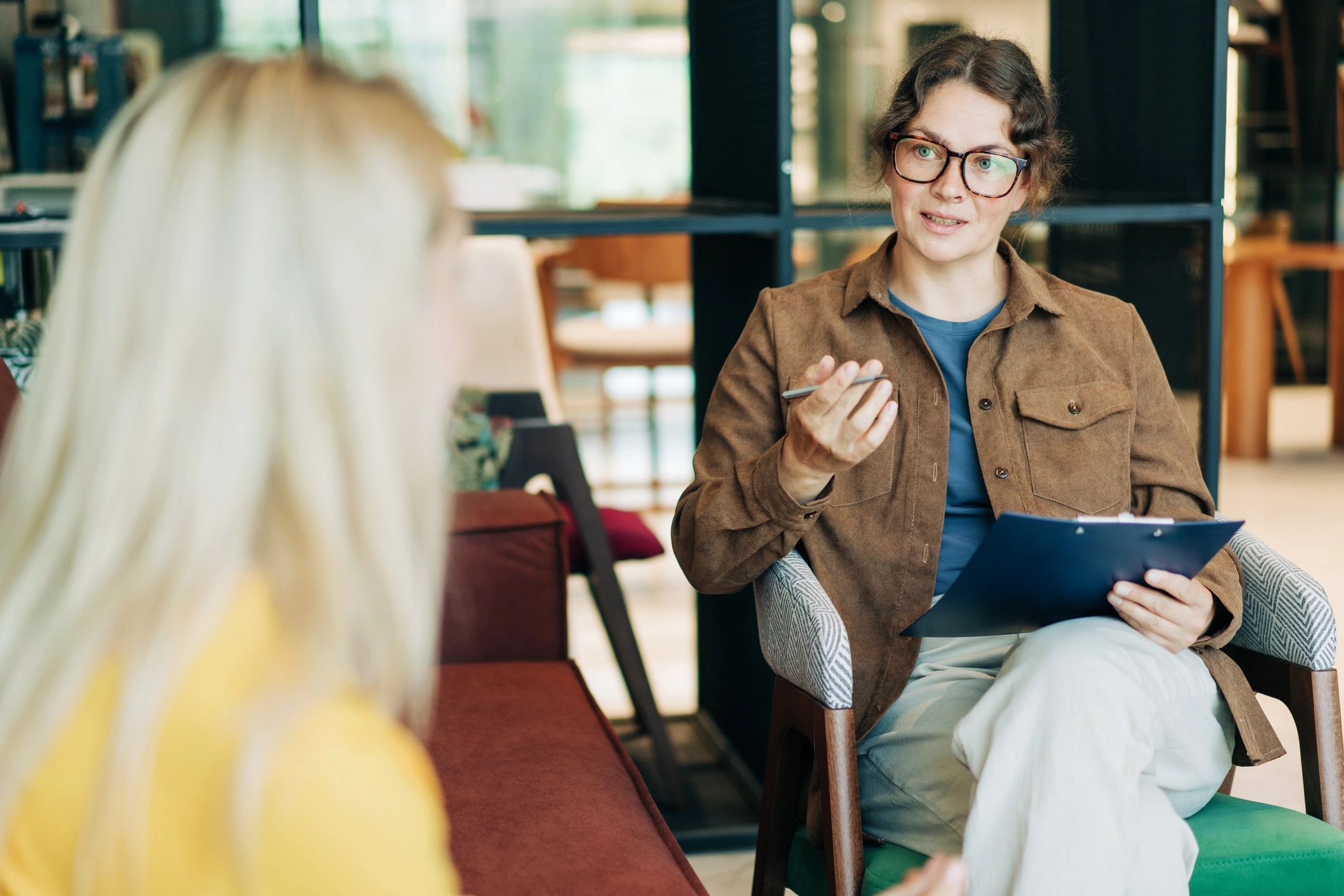 Professional advisor speaking with a client in an office setting.