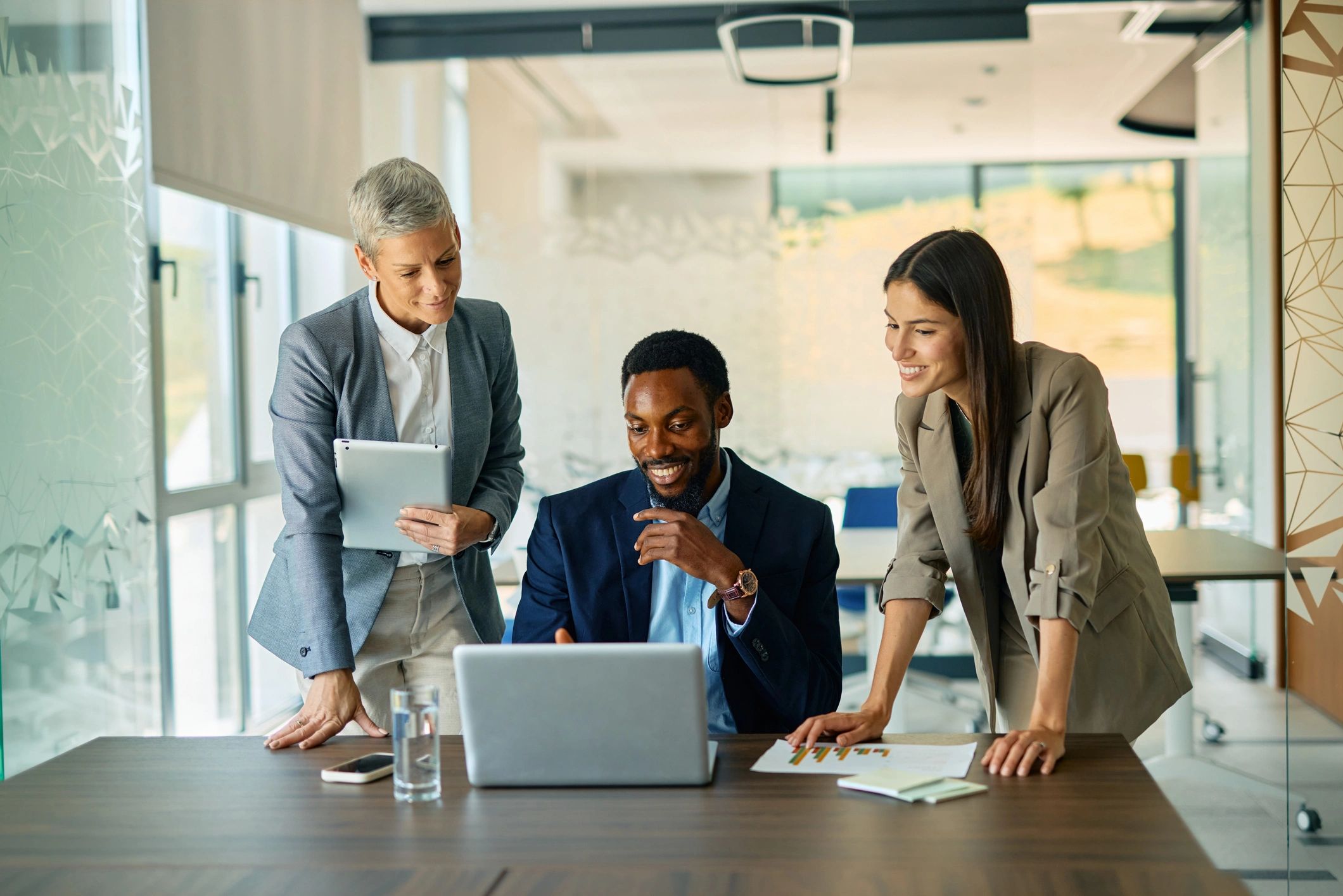 Business team collaborating around a laptop in a modern office